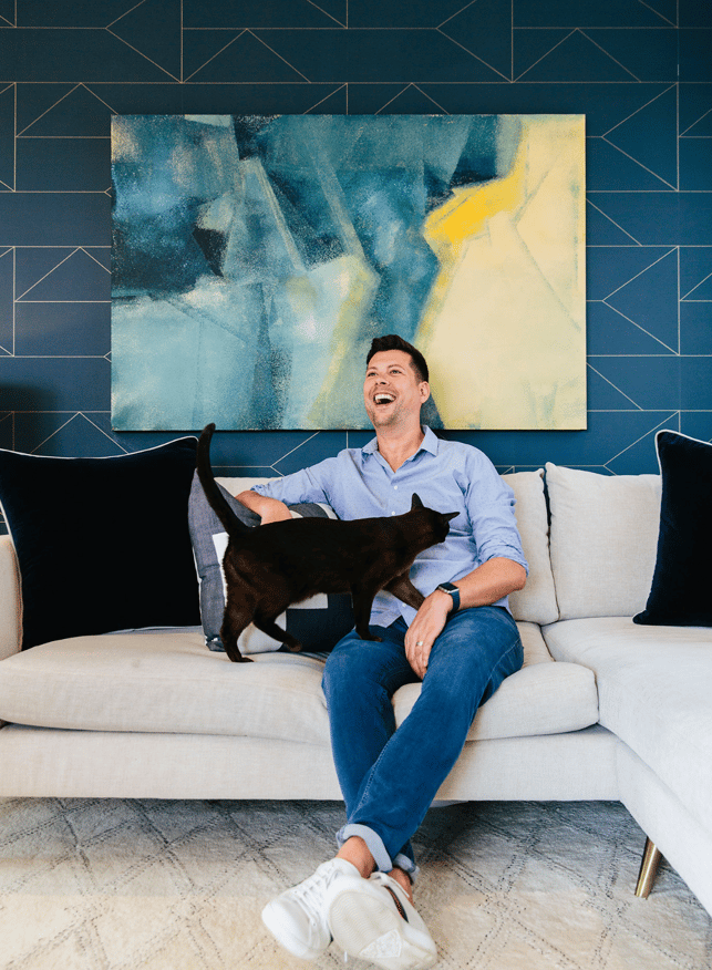 Happy home man laughing with cat in interior designed london flat 